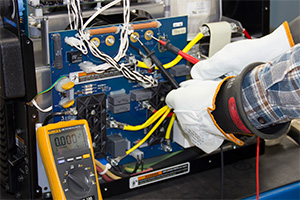 gloved hands working on a machine