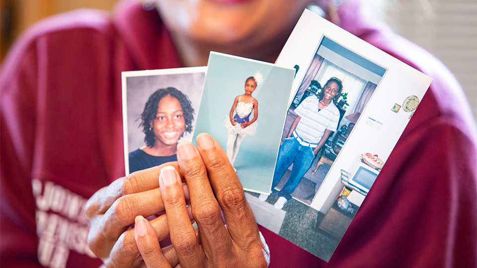 Pa'Trice Frazier's mother holding pictures of her as a child