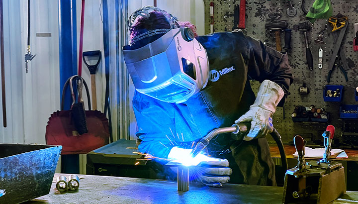 Operator MIG welds in manufacturing environment