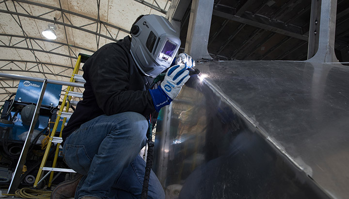 Welder TIG welding on aluminum boat with Dynasty 400
