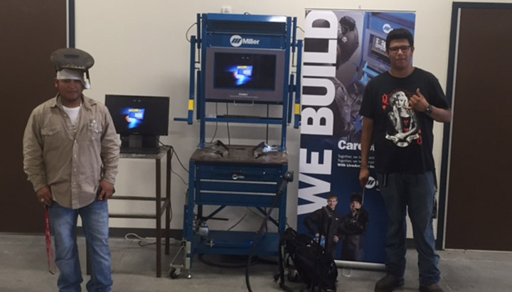Students standing beside Live Arc Welding Performance Management System