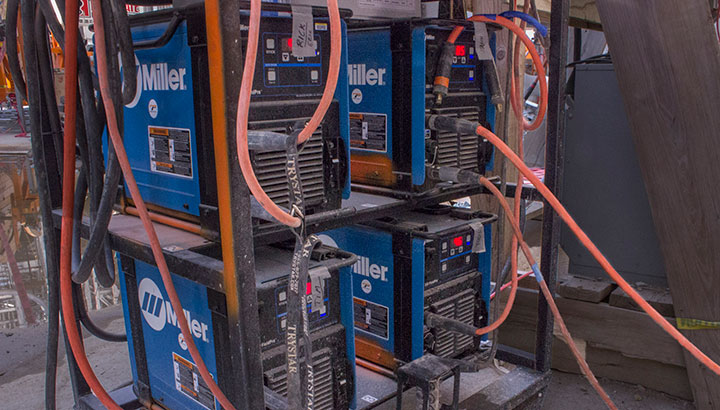 four Miller XMT welders on a rack