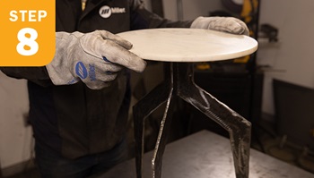 placing a marble table top onto metal table base