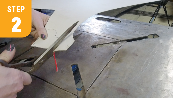 Metalworker uses a metal shear to cut a piece of paper